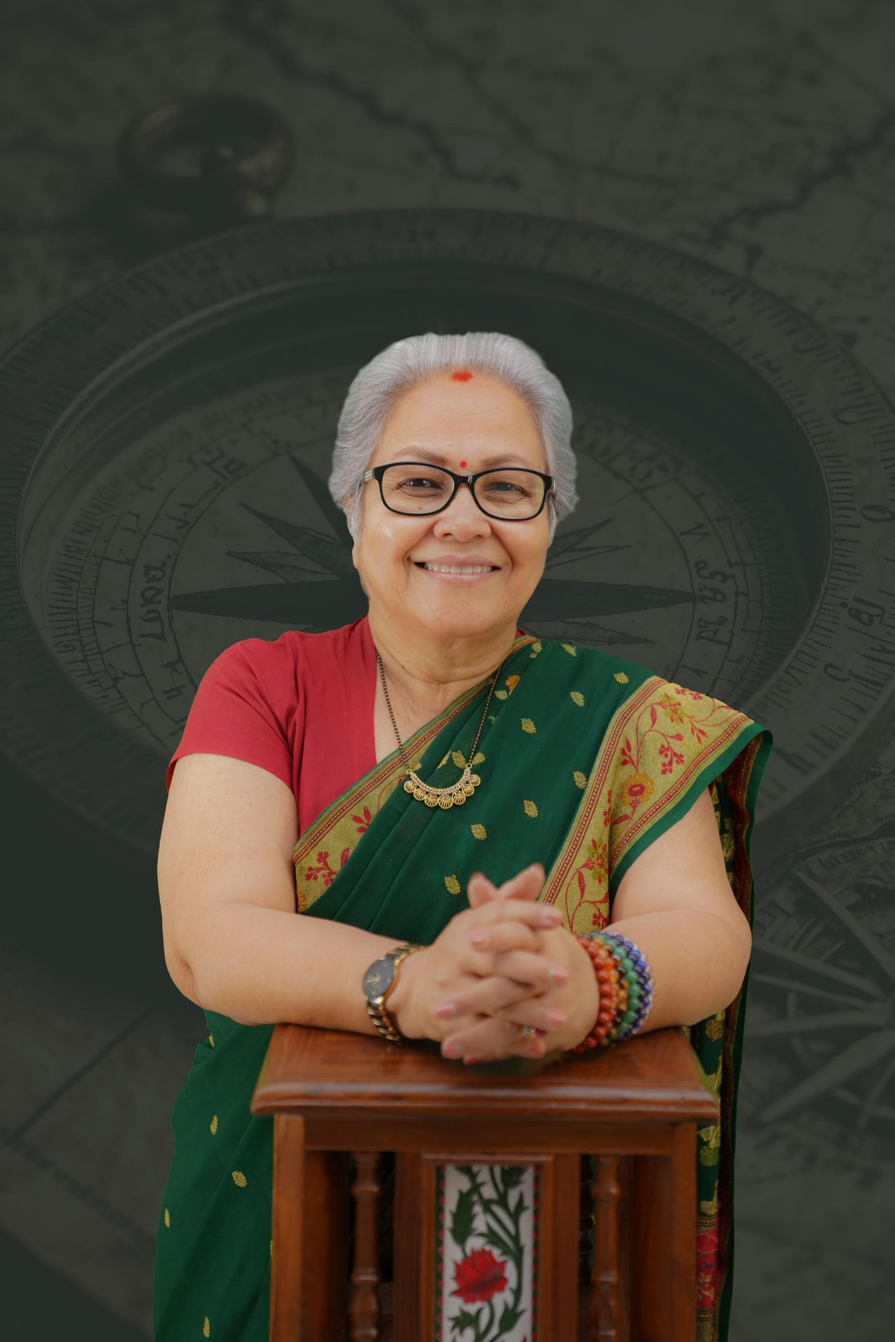 Sharda Karve seated calmly in a green sari
