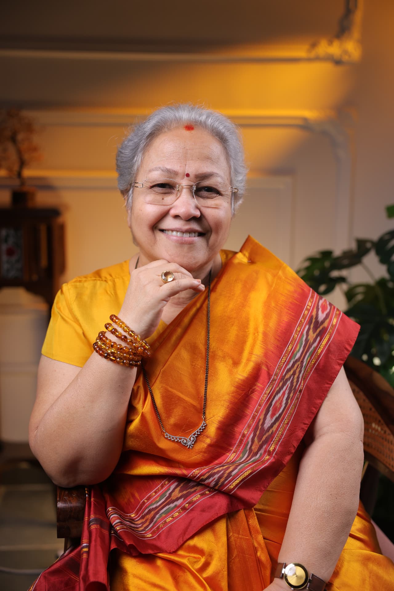 Sharda Karve smiling in an orange sari