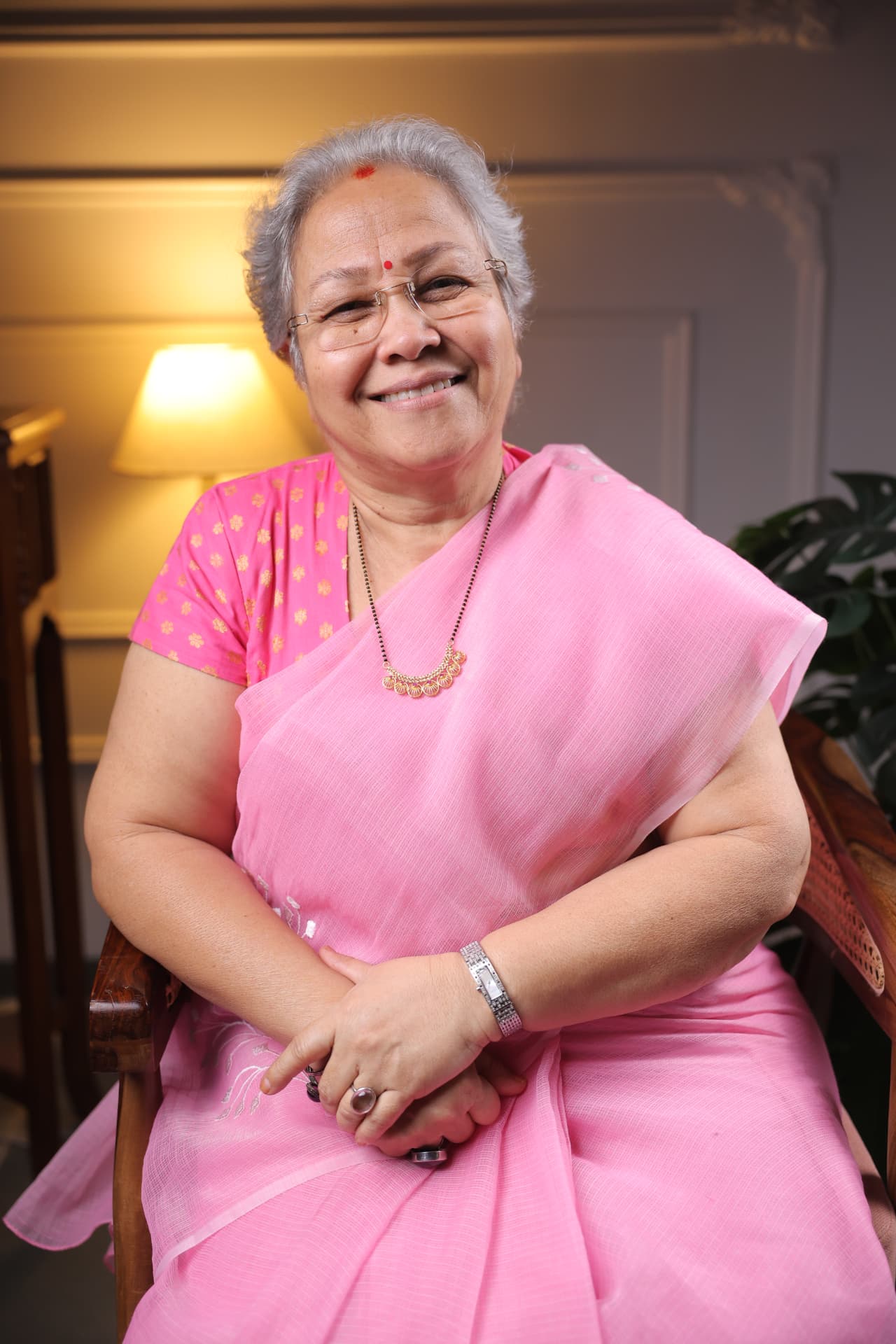 Sharda Karve seated in a pink sari
